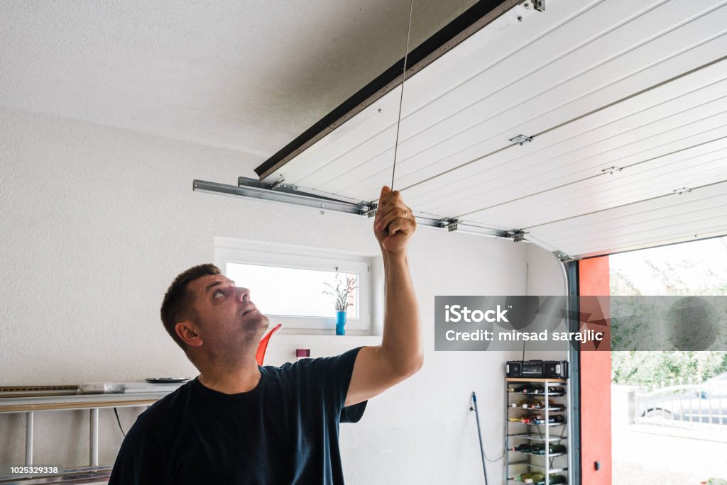 Garage door PVC man opens pvc garage door manually Garage Stock Photo