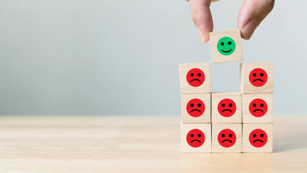 istock Hand picked wooden block with icon face emotion happiness and sadness, Unique, think different, individual and standing out from the crowd concept 1025332626