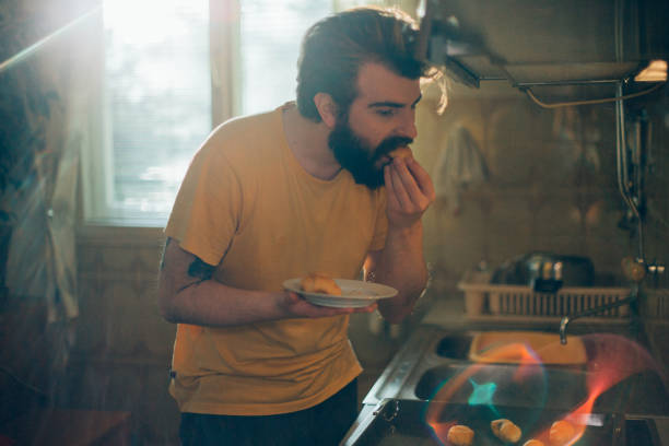 istock Young man eating freshly baked pastries in the kitchen 1025370066