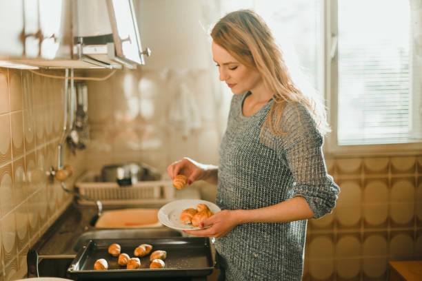 istock Beautiful young woman baking pastries in the kitchen 1025372190