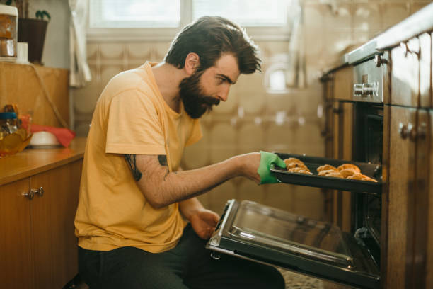 istock Casual dressed man baking pastries in the kitchen at home 1025372608