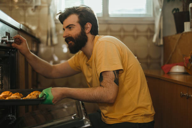 istock Casual dressed man baking pastries in the kitchen at home 1025372632