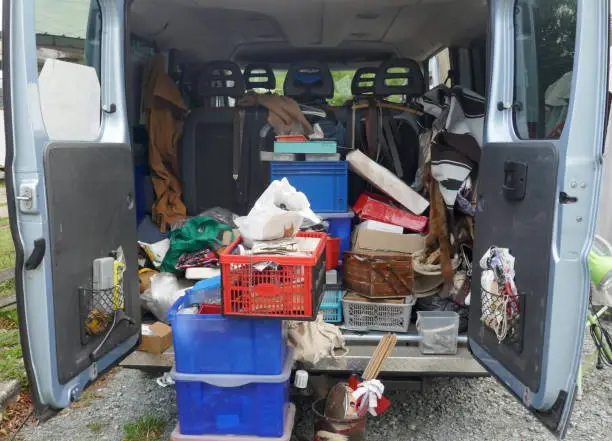 Photo of Open, untidy trunk,loaded with old tools, scrap and garbage