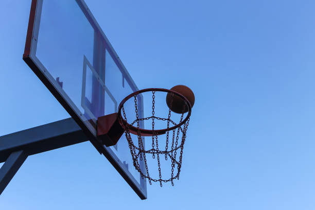 istock Basketball ring with metal chains against the blue sky 1025407258