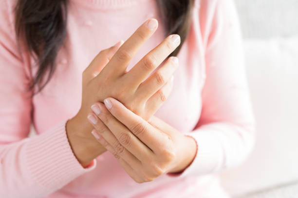 detalle mujer sentada en sofá tiene su lesión en la mano muñeca, sensación de dolor. concepto de salud y médico. - pain joint human hand arthritis fotografías e imágenes de stock