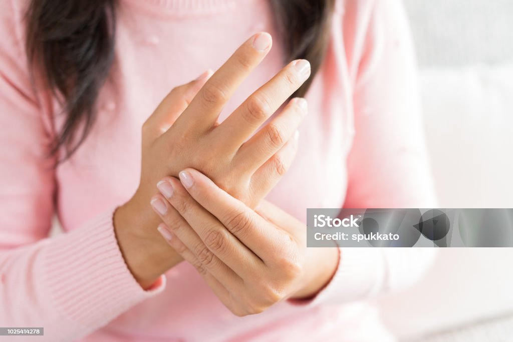 ソファーに座っていたクローズ アップ女性は、痛みを感じ彼女の手首の手の怪我を保持します。ヘルスケアと医療の概念。 - 手のロイヤリティフリーストックフォト