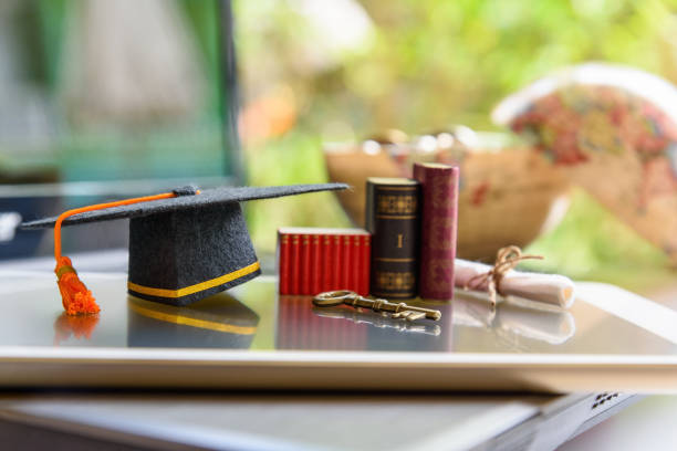 istock Graduate study abroad program for opening or expand world view concept : Graduation cap or hat, a key, world globe map, foreign text book on laptop, depicts achievement or success in online education 1025416692