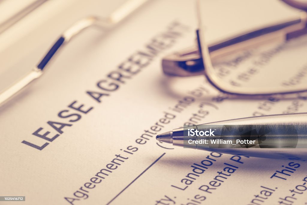 Business legal document concept : Pen and glasses on a lease agreement form. Lease agreement is a contract between a lessor and a lessee that allow lessee rights to use of a property owned by lessor Lease Agreement Stock Photo