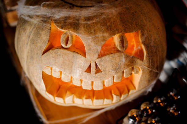 Halloween horror pumpkin with the light inside on the party on the dark background