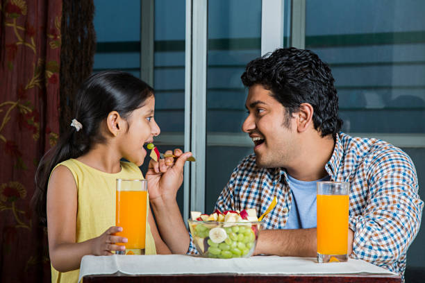 istock Dad and daughter eating fruit - Stock image 1025419996
