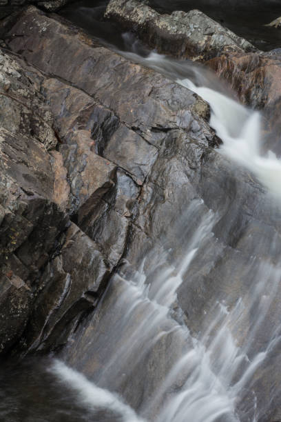 diagonal caídas de agua a través de una pared de roca en las grandes montañas humeantes - boulder flowing water mountain range rock face fotografías e imágenes de stock