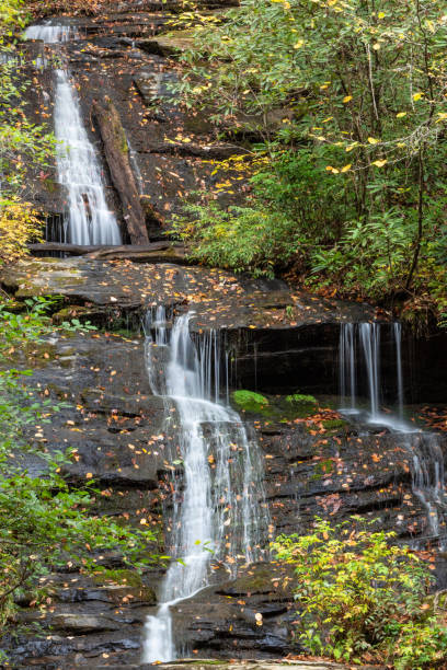 istock Multi tiered waterfall across wet rocks covered in autumn leaves and moss 1025420612