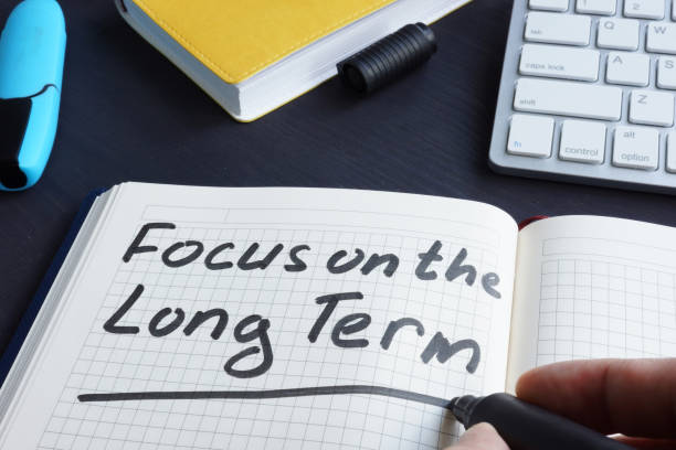 Man is writing focus on the long term. Man is writing focus on the long term. long stock pictures, royalty-free photos & images