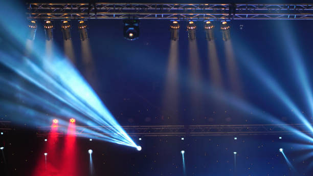 istock Luminous rays from concert lighting against a dark background over the projector screen, musical instrument concept 1025426354