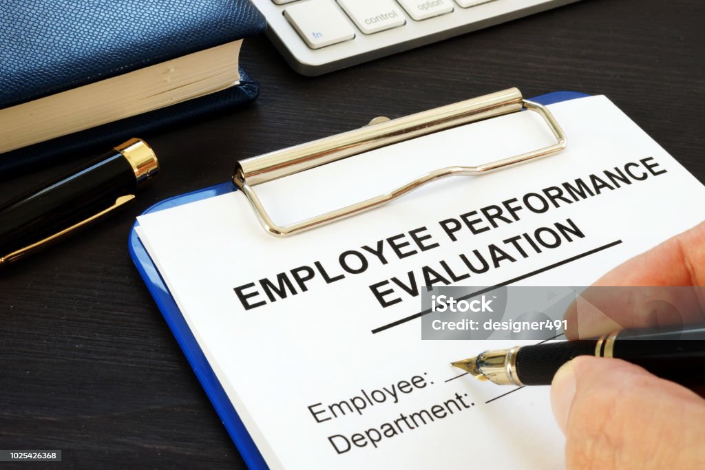 Clipboard with employee performance evaluation and pen. Employee Stock Photo