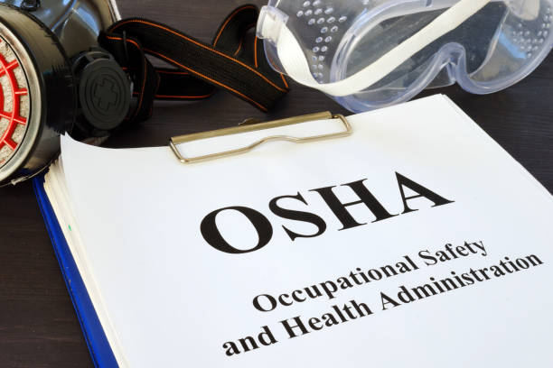 stapel von dokumenten mit occupational safety and health administration osha. - arbeitssicherheit stock-fotos und bilder
