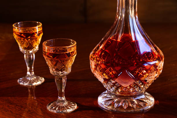 garrafa de cristal e copos cheios de rum, jarra de vidro e um gole de álcool em uma mesa de madeira - decanter crystal carafe glass - fotografias e filmes do acervo