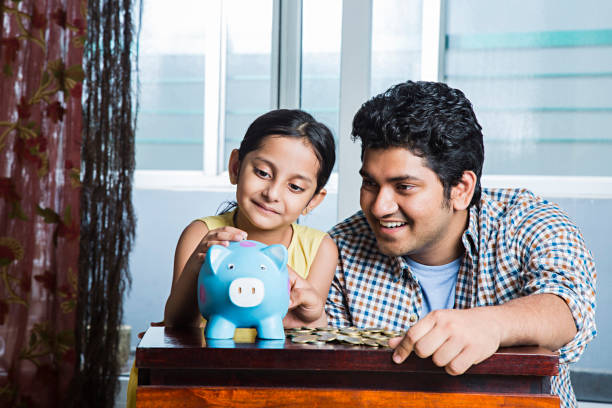 istock Father teaching daughter to save money - Stock image 1025431610
