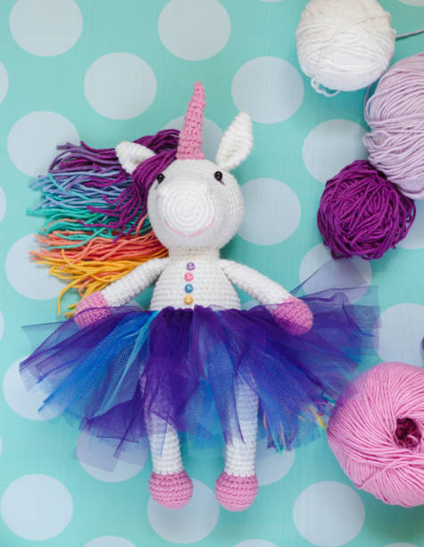 istock Knitted white unicorn in colored clothes. 1025439470