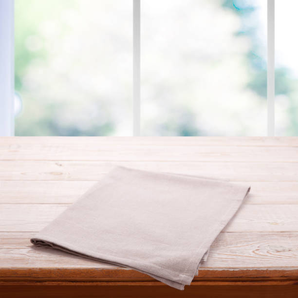 istock Empty wooden table with tablecloth. Napkin close up top view mock up. Kitchen rustic background with window. 1025477510