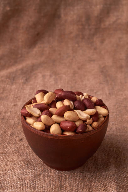 istock walnut peanut in clay bowl. peanuts for food textures. peanut harvest. fried peanuts. texture of the nuts. photo for layout. Copyspace 1025490466