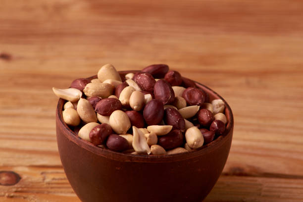 istock dry peanuts background. close up dry peanuts in clay bowl. Space for pext. Copyspace 1025490610