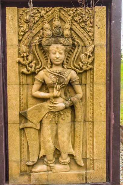 una danza apsara scolpita sullo sfondo del muro di arenaria. l'apsara è uno spirito femminile delle nuvole e delle acque della cultura indù. la sua figura è prominente nella scultura, nella danza, nella letteratura e nella pittura. - carving cambodia decoration thailand foto e immagini stock