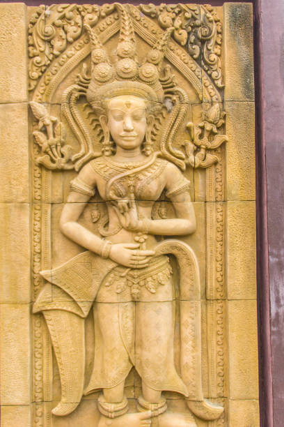 una danza apsara scolpita sullo sfondo del muro di arenaria. l'apsara è uno spirito femminile delle nuvole e delle acque della cultura indù. la sua figura è prominente nella scultura, nella danza, nella letteratura e nella pittura. - carving cambodia decoration thailand foto e immagini stock