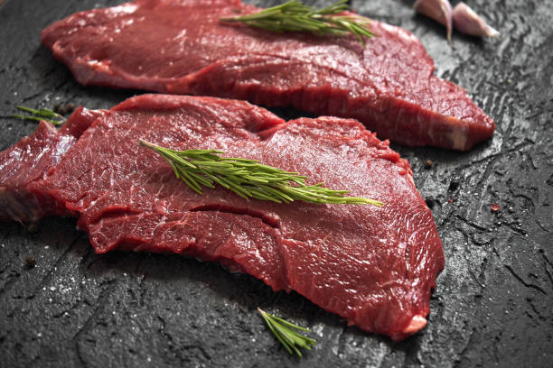 istock Raw ribeye beefsteak with seasonings, black background 1025526032