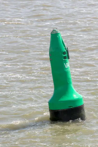 Green buoy as a marker for shipping on the UNESCO protected Wadden Sea in the North of the Netherlands