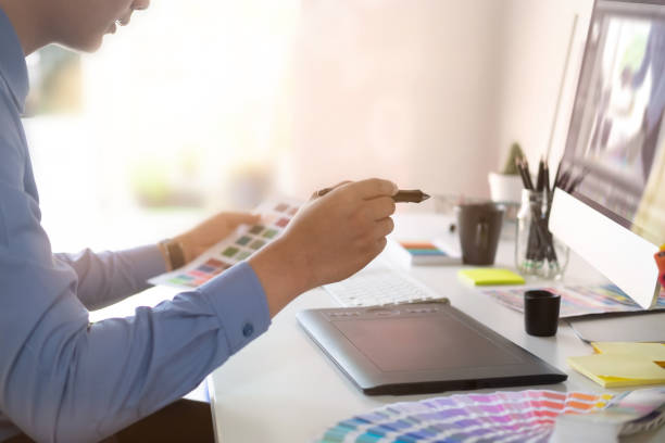 istock Graphic designer working with digital tablet and mouse pen on table and morning light. 1025534076
