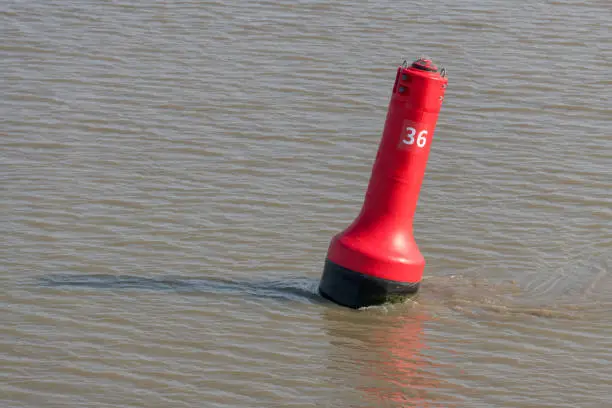 Red buoy as a marker for shipping on the UNESCO protected Wadden Sea in the North of the Netherlands