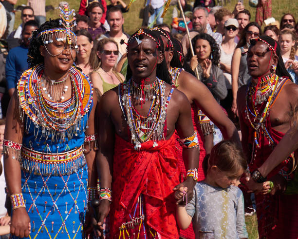 September 26, 2024 - makuyuni, Arusha, Tanzania: Group of Maasai men, donned in vibrant traditional clothing and intricate masks, parading during a lively ceremony in a village near Arusha, Tanzania, celebrating their rich culture and heritage