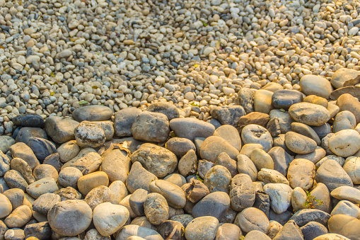 Coarse and fine river gravels for background. Big and small river pebbles texture background.