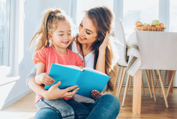 istock Mother and daughter reading a book together 1025583790