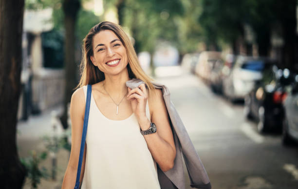 istock Smiling woman with coat on shoulder 1025583832