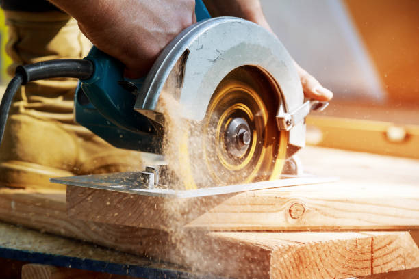 istock Building contractor worker using hand held worm drive circular saw to cut boards on a new home constructiion project 1025587654