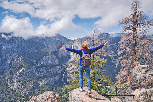 Happy girl with wide open arms in Yosemite Park.