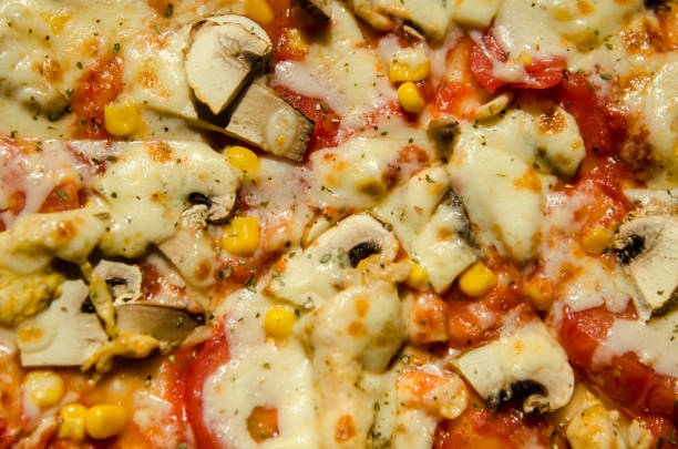 top view close up hot pizza with mushrooms, bell pepper, tomato and sweet corn