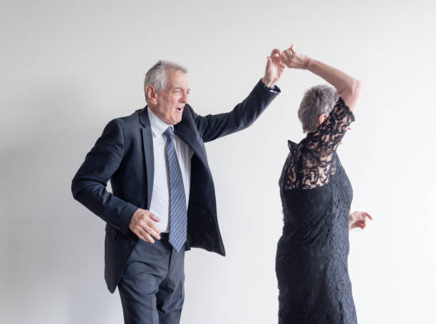 istock Senior Couple Dancing Against White Background 1025610780