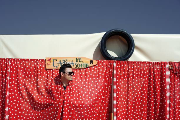 istock Man Hiding Behind Red Curtain Against Clear Sky 1025633704