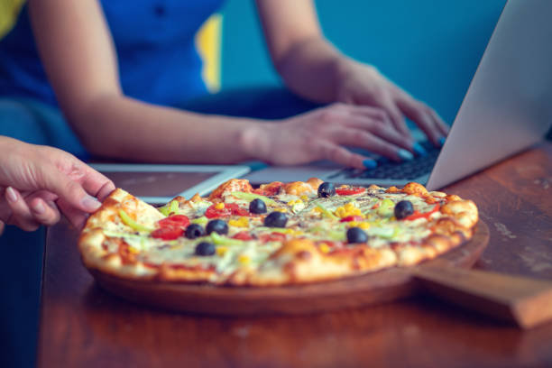 istock Mock up freelancer workplace. Tablet PC, cell phone and pizza. Top view image. Fast pizza delivery 1025661536