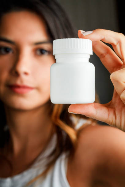 istock Hispanic young woman holding a white plastic medicine bottle 1025666054