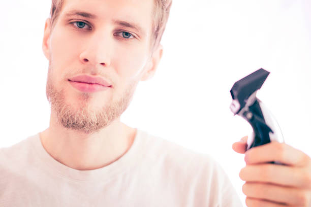 istock young bearded handsome barber with shaving machine isolated on a white background 1025666184