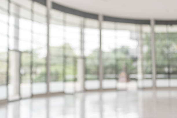 blur background interior view looking out toward to empty office lobby and entrance doors and glass curtain wall - window glass fotos imagens e fotografias de stock