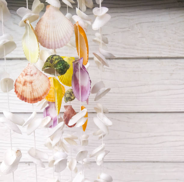 istock Shell hanging mobile on white wooden background 1025692186