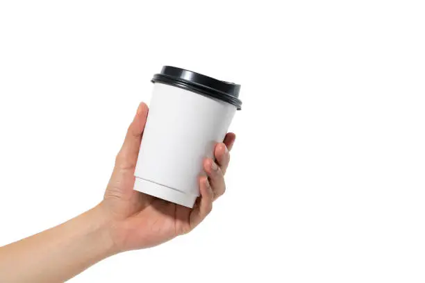 female hand holding a coffee paper cup isolated on white background.