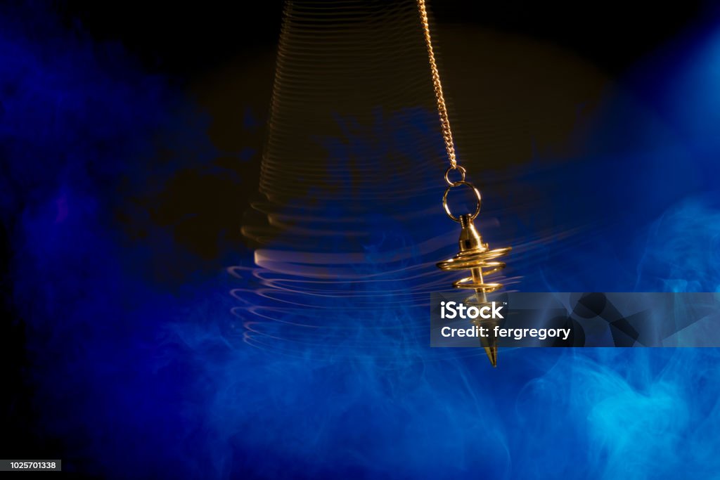 Hypnotism pendulum swinging with motion blur Pendulum used for hypnotism and readings swinging with motion blur Hypnosis Stock Photo