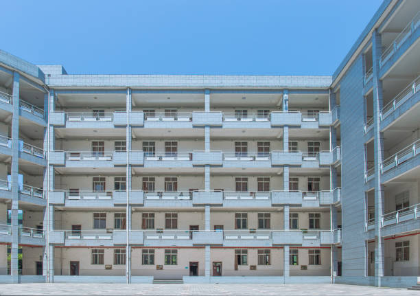 istock Modern school building on the university campus, surrounded by floors, with a square in the middle, sunny in summer 1025728374