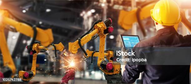 Engineer Check And Control Welding Robotics Automatic Arms Machine In Intelligent Factory Automotive Industrial With Monitoring System Software Digital Manufacturing Operation Industry 40 Stock Photo - Download Image Now